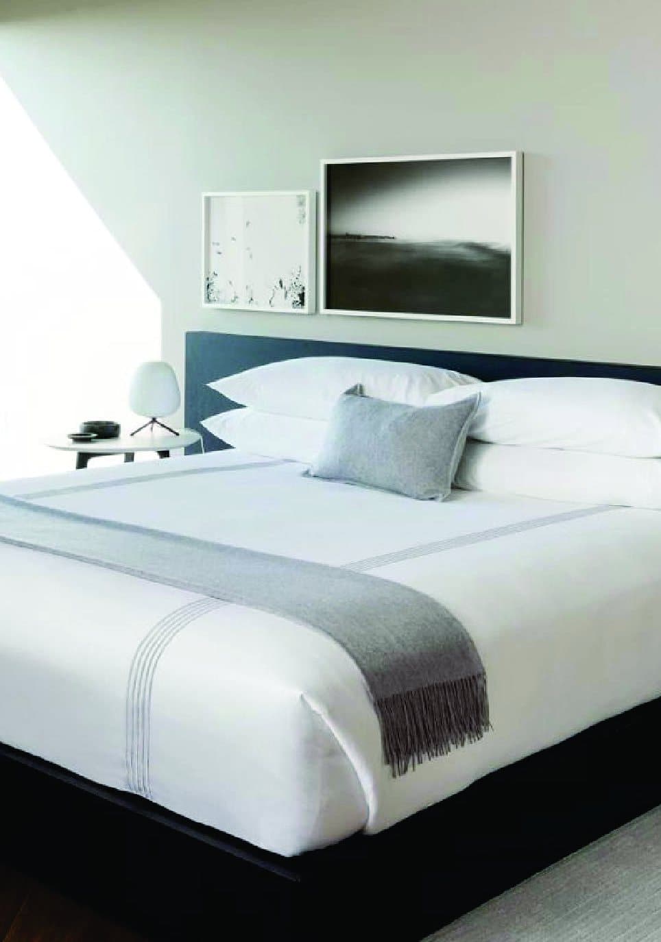 Kamar hotel dengan bed linen putih YMH terpasang rapi